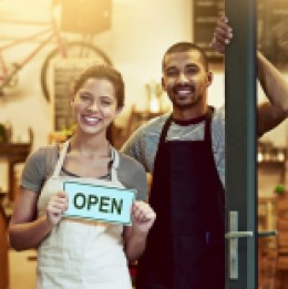male and female small business owner couple opening their doors for the first time