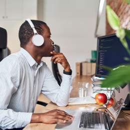Man with headphones on sitting at a computer