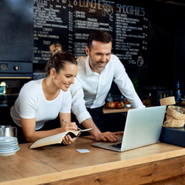 Business owners working together and looking at laptop
