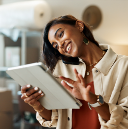 Female business owner looking at information on her tablet while on the phone in her business location
