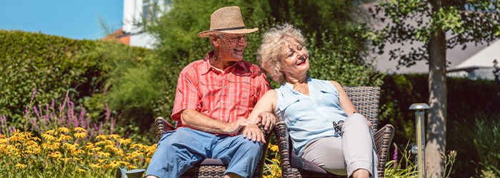 Retired couple sitting outside in the sunshine