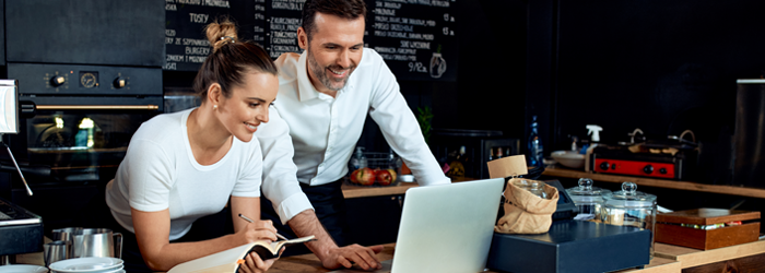 Business owners working together and looking at laptop