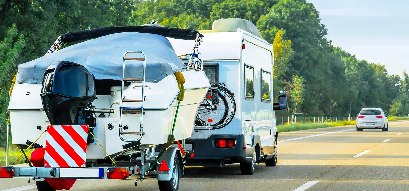 RV towing boat on the road