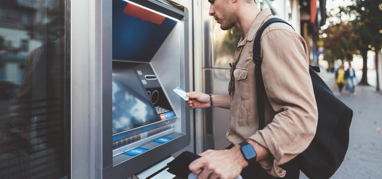 man inserting his card into an ITM machine