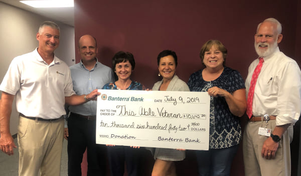 TAV staff posing with large check