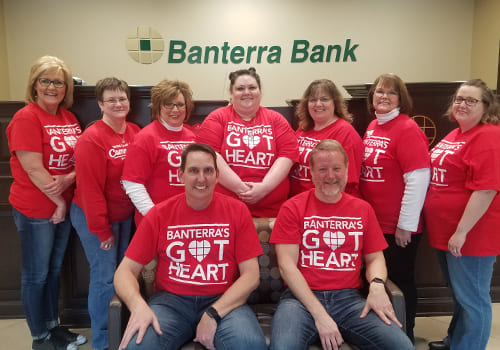 group photo people in matching red tshirts with Banterra sign behind