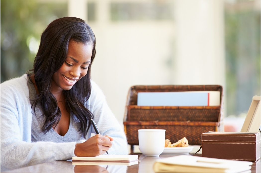 woman smiling and writing something down