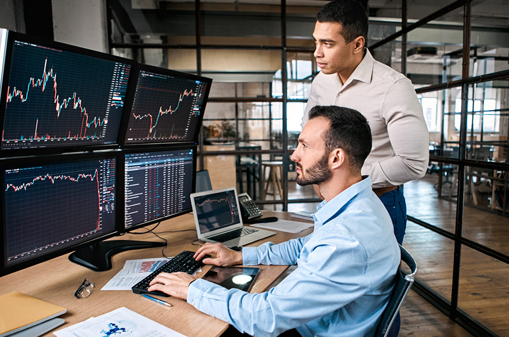 men at computer looking at graphs