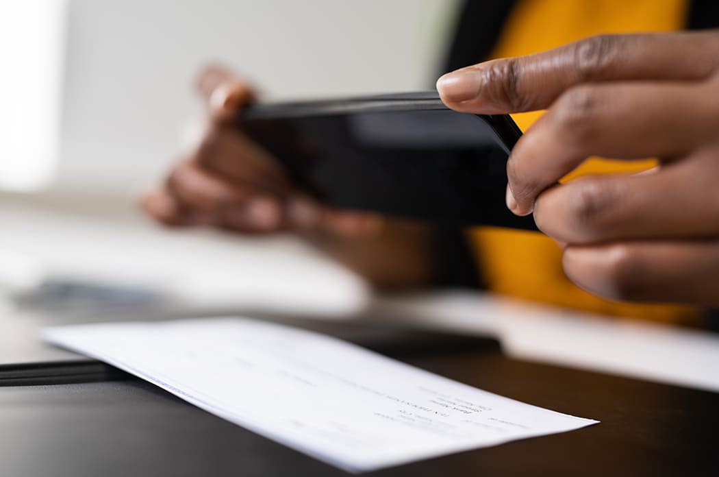 woman using phone to take a photo of a check to deposit