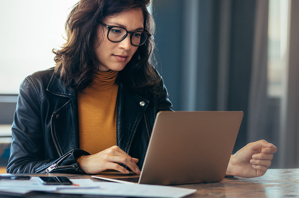 young woman with glasses on laptop